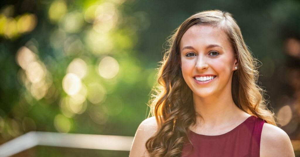 bethany, a patient of Nth Degree Orthodontics in south carolina smiles in forest