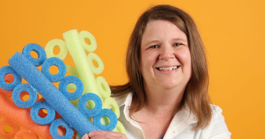 adult holding up fun noodle elastics before eating out with braces